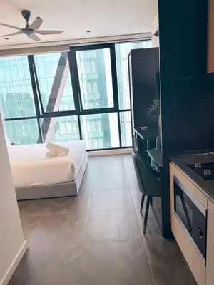 a bedroom with a bed and a desk in a building at Scarletz Suites KLCC by Dream in Kuala Lumpur