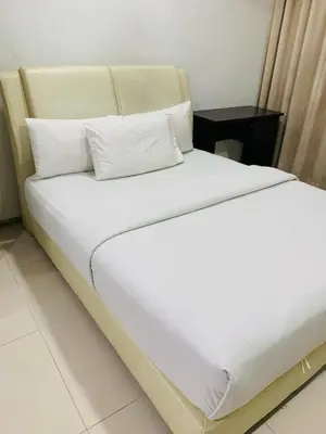 a bed with white sheets and pillows in a room at Residence at tarragon kl in Kuala Lumpur