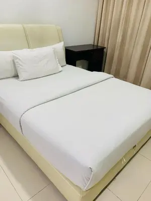 a large white bed in a room with a table at Residence at tarragon kl in Kuala Lumpur