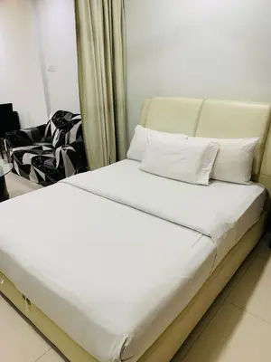a bed with white sheets and pillows in a room at Residence at tarragon kl in Kuala Lumpur