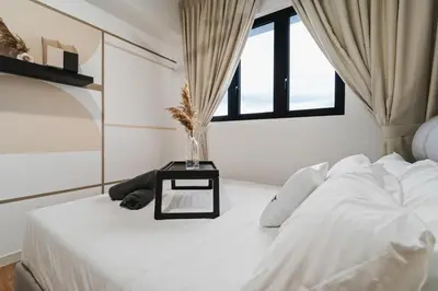 a white bed with a vase on a table at Trendy 3BR MVertica Near MRT by RumaBnB in Kuala Lumpur