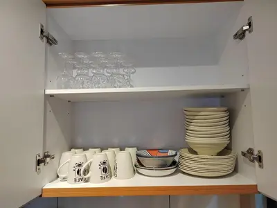 a cupboard filled with plates and bowls and dishes at 10pax Comfy Homestay 5 Min-MITEC in Kuala Lumpur