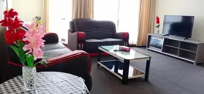 a living room with a couch and a tv at Urban Suite At Times Square KL in Kuala Lumpur