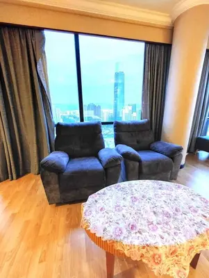 a living room with two chairs and a table and a window at Urban Suite At Times Square KL in Kuala Lumpur