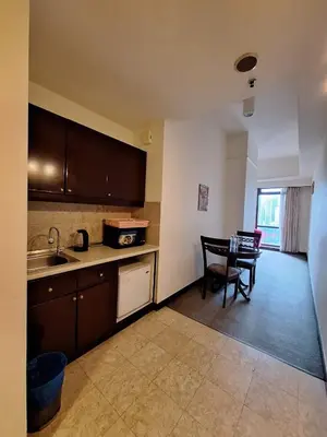a kitchen with a sink and a table with chairs at Urban Suite At Times Square KL in Kuala Lumpur