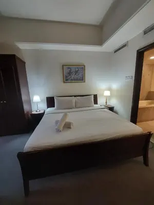 a bedroom with a large bed with a book on it at Rainfall Suite And Service at Time Squre KL in Kuala Lumpur