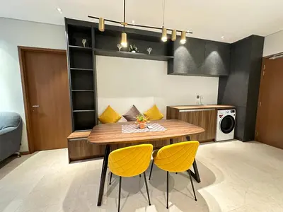 a kitchen with a wooden table and two yellow chairs at Sky Suites KLCC by The Sense in Kuala Lumpur