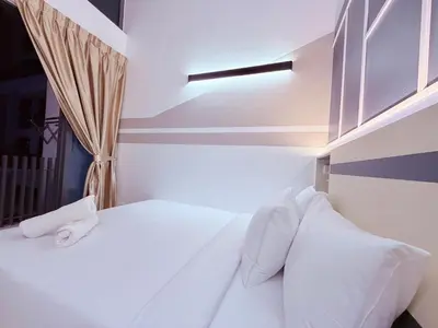 a bedroom with a white bed with white pillows at Colony Relax Residences Klcc in Kuala Lumpur