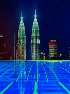 two tall skyscrapers in a city at night at Colony Greenfield Suites Klcc in Kuala Lumpur
