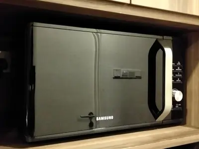 a microwave oven sitting on a shelf at CozyNest Suites Bukit Bintang in Kuala Lumpur