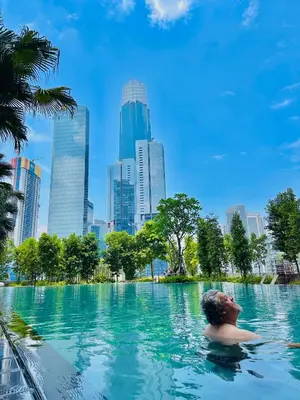 a man swimming in a pool in a city at Agile Suites TRX KlCC in Kuala Lumpur