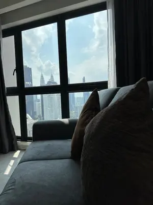 a couch in a room with a large window at Agile Suites TRX KlCC in Kuala Lumpur