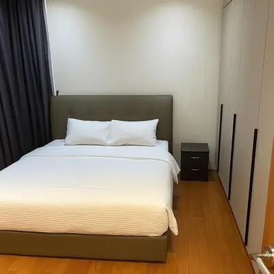 a bedroom with a large bed with a night stand at Dawn Legacy Suite in Kuala Lumpur