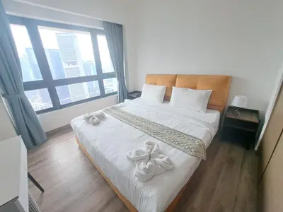 a bedroom with a bed with white sheets and a window at Agile Malaysia Apartment KL in Kuala Lumpur