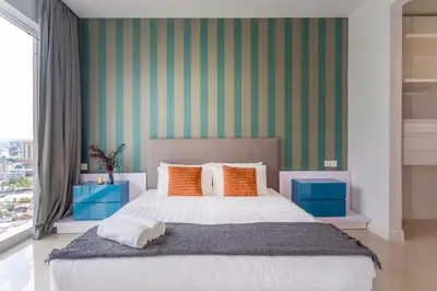 a bedroom with a large bed with orange pillows at Platinum in Kuala Lumpur