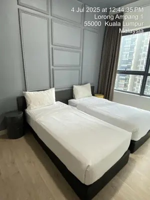 two beds sitting in a room with a window at NiceStay in Kuala Lumpur