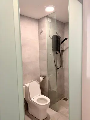 a bathroom with a toilet and a glass shower at COzy Suite KL Sentral By Riveria City in Kuala Lumpur