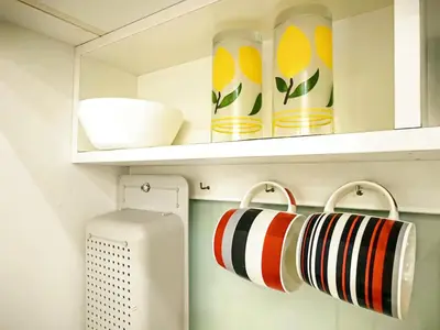 a shelf with cups and bowls on it in a kitchen at Setapak Central KL - Zetapark Summer Suites in Kuala Lumpur