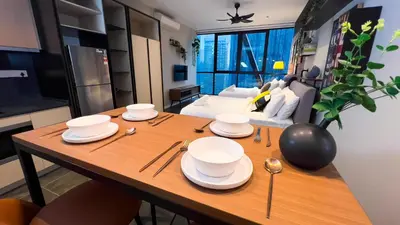 a table with plates and spoons on it in a living room at Scarletz Suite KLCC by Light House 1 in Kuala Lumpur
