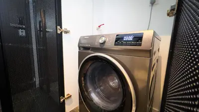 a washing machine in a room next to a door at Scarletz Suite KLCC by Light House 1 in Kuala Lumpur