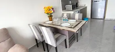 a dining room table with chairs and flowers on it at Agile Service Residence by TRX KLCC in Kuala Lumpur
