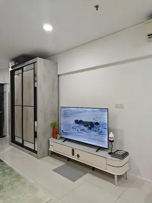 a living room with a large flat screen tv on a wall at Summer Suites Klcc by Sikka in Kuala Lumpur
