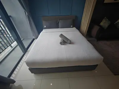 a bed in a room with a white mattress and a bottle on it at Chambers Vista Suites Urban Haven KLCC in Kuala Lumpur