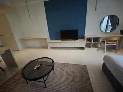 a living room with a glass table and a tv at Chambers Vista Suites Urban Haven KLCC in Kuala Lumpur