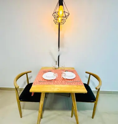 a wooden table with two chairs and a lamp at The Luxe & Colony KLCC By LuxeHub in Kuala Lumpur