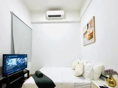 a white room with a bed and a tv at The Luxe & Colony KLCC By LuxeHub in Kuala Lumpur
