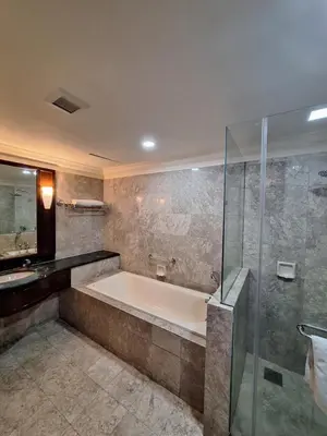 a bathroom with a tub and a glass shower at KL Times Square Hotel Service Suite in Kuala Lumpur