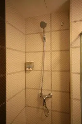 a shower with a glass door in a bathroom at Cardogan Hotel in Kuala Lumpur