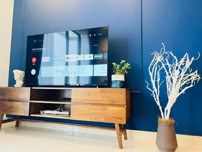 a living room with a tv on a blue wall at trion kl TRX klcc view in Kuala Lumpur