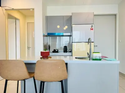 a kitchen with a counter with two chairs and a sink at trion kl TRX klcc view in Kuala Lumpur