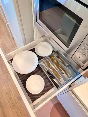 a kitchen with three white plates and a microwave at The Calma, Platinum Suites 2 BR in Kuala Lumpur