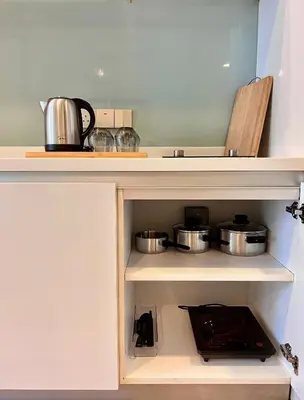 a kitchen with two pots and pans on a shelf at The Calma, Platinum Suites 2 BR in Kuala Lumpur