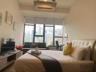 a bedroom with a large bed and a living room at Staybliss At Ceylonz Suites KLCC in Kuala Lumpur