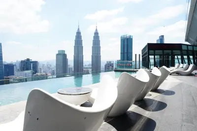 a pool with white chairs on the roof of a building at Imperial Residences KLCC - MK HOME in Kuala Lumpur