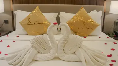 two swans made out of towels on a bed at Imperial Residences KLCC - MK HOME in Kuala Lumpur