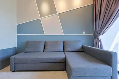 a blue couch in a room with a window at Luxurious TRX Corner Dual Balconies 2 Bedrooms in Kuala Lumpur