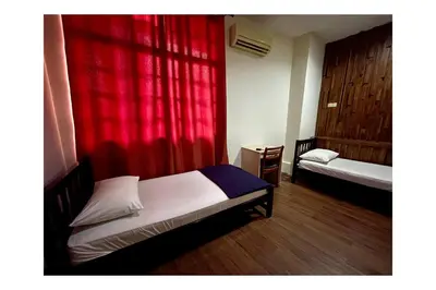 a bedroom with two beds and a red curtain at The Explorers Guesthouse and Hostel in Kuala Lumpur