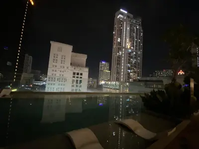 a city skyline at night with a swimming pool at Comfort Suites At Quill Residence in Kuala Lumpur