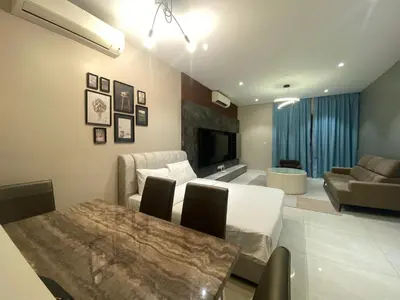 a living room with a dining table and a couch at Comfort Suites At Quill Residence in Kuala Lumpur