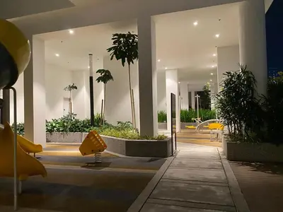 a lobby of a building with chairs and plants at Comfort Suites At Quill Residence in Kuala Lumpur
