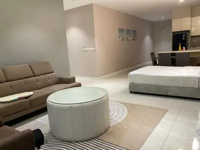 a living room with a bed and a couch and a table at Comfort Suites At Quill Residence in Kuala Lumpur