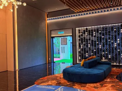 a lobby with a blue couch and a wall of wine bottles at Majestic Premium suites KLCC in Kuala Lumpur