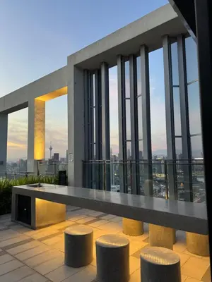 a view of a building with a table and stools at trion Klcc 2 bedroom apartment in Kuala Lumpur