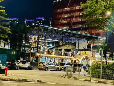 a building with cars parked in a parking lot at night at KLCC Scarletz Residence Near By KL in Kuala Lumpur