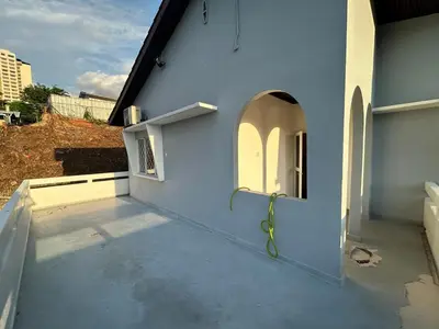 a building with a blue wall with a green hose at The Little Bali - 6Room - 18Pax in Kuala Lumpur
