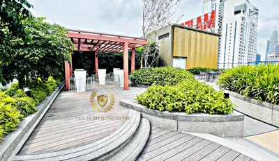 a wooden boardwalk with tables and plants in a city at The Majestic Gen Luxury Suites KLCC in Kuala Lumpur
